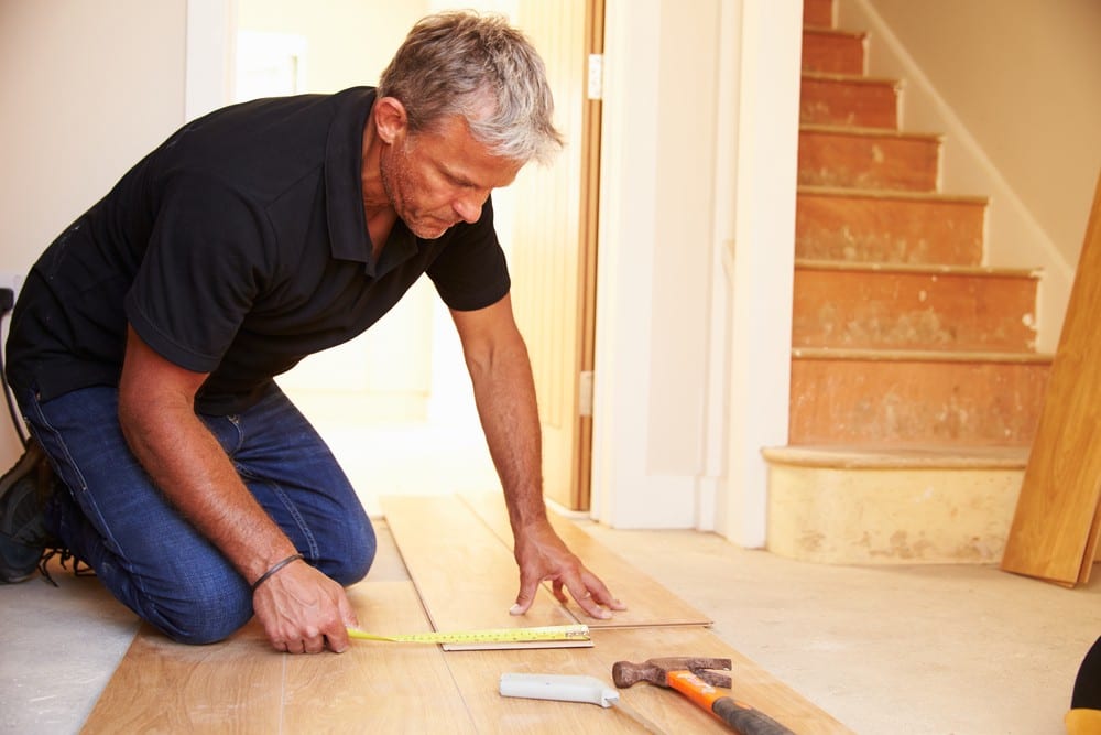Man measuring hardwood | All American Flooring