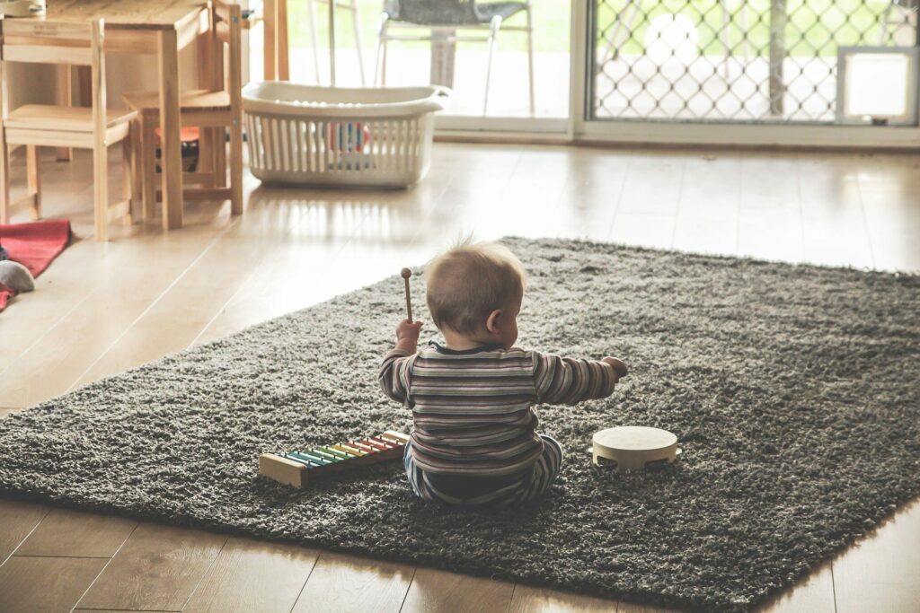 Baby plying on carpet floor | All American Flooring