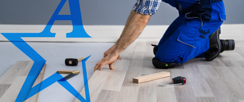 a man in blue pants is kneeling down on a wooden floor